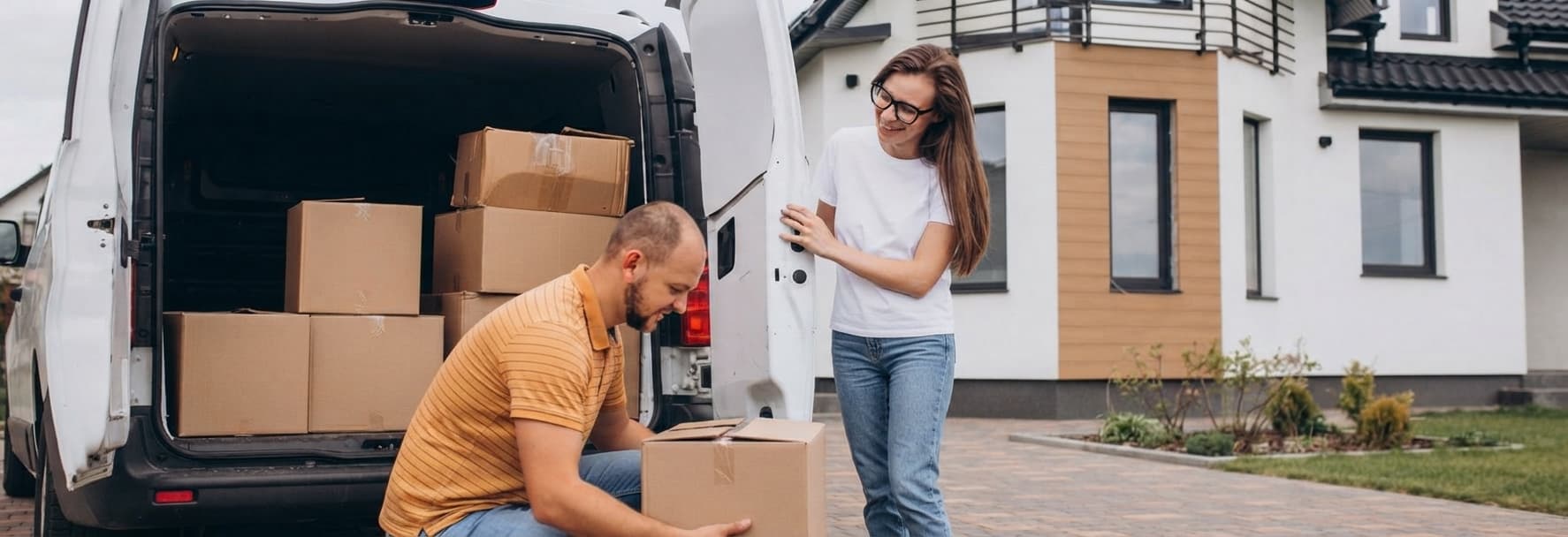 Homeowners loading boxes into a van while moving house