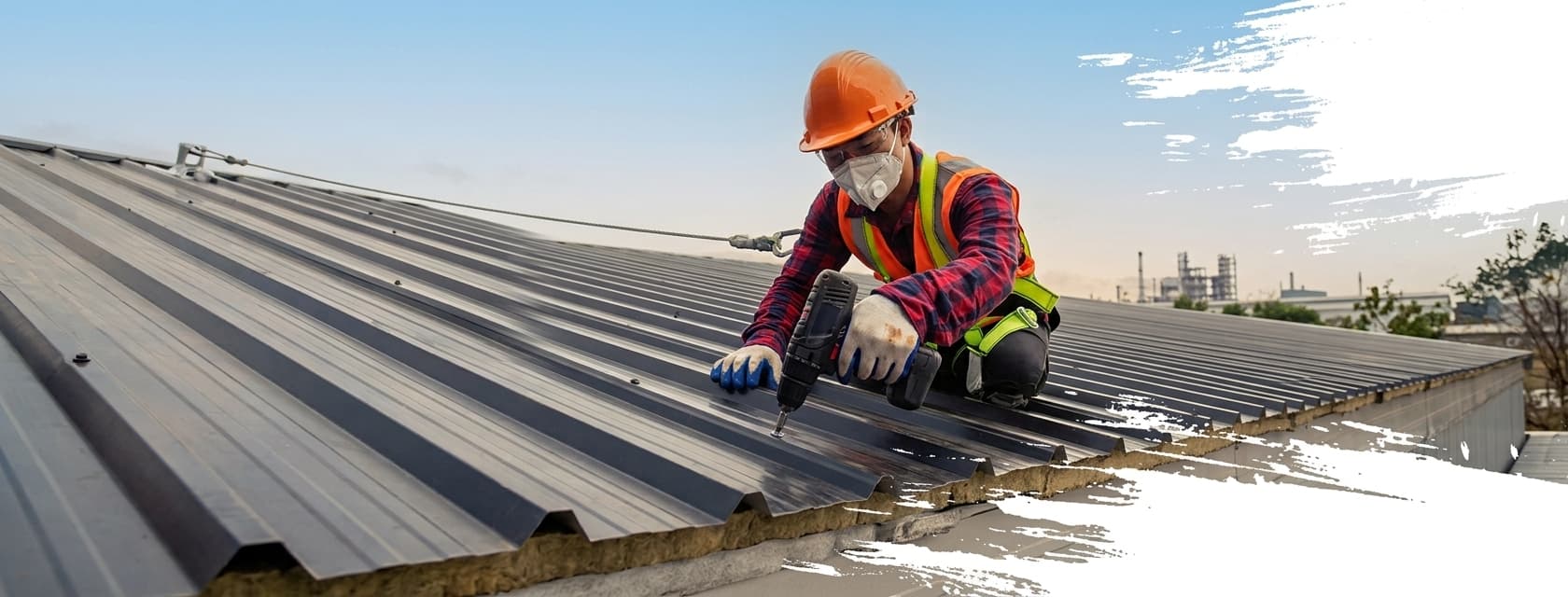 Roofer fastening standing-seam metal roof panels with a drill