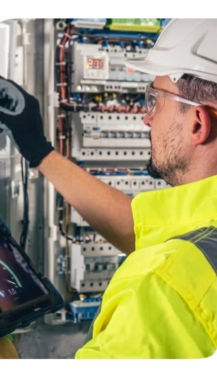 Electrician checking wiring inside an open circuit breaker panel