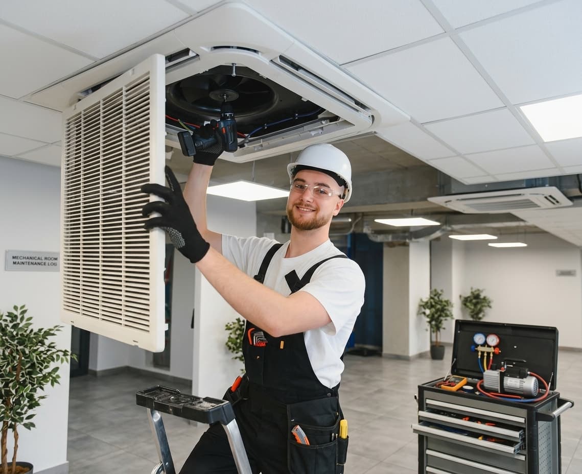 HVAC technician working on ceiling ductwork