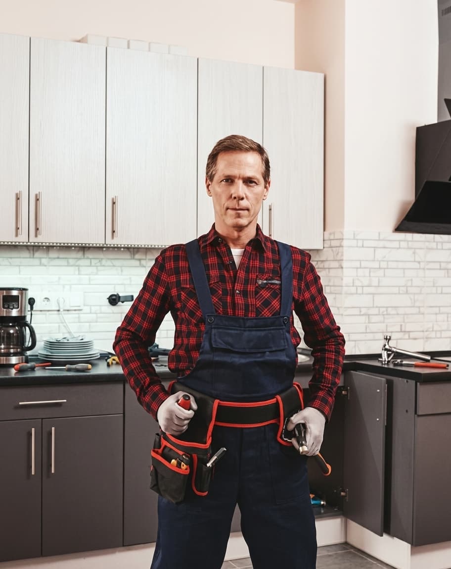 Plumber standing in a client's kitchen